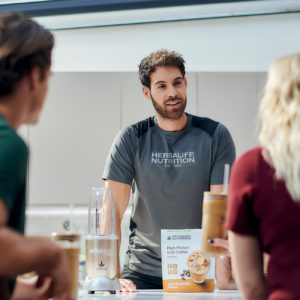 herbalife nutrition coach talking to his customers in a nutrition club